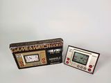 a game and watch in a box next to a game and watch
