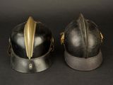 pair of black helmets with gold accents on a black background