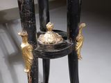 a black and gold table with two candles on top of it