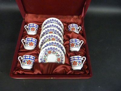 six tasses et une soucoupe dans une boîte rouge