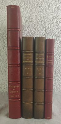 several old books are lined up on a white surface