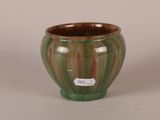 a green and brown vase with a tag on it