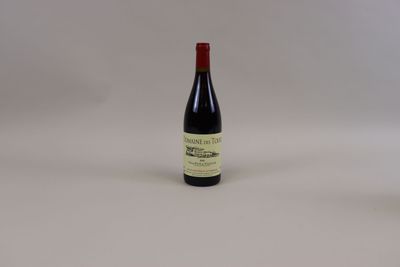 une bouteille de vin rouge posée sur une table blanche