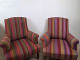 deux chaises rayées aux couleurs vives, placées l'une à côté de l'autre sur un parquet