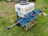 a close up of a tractor with a sprayer in the grass