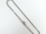 a close up of a silver chain with a heart on it