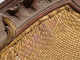 a wicker chair with a wooden seat and back rest