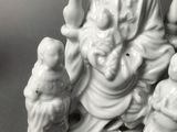 a figurine of a person sitting on a tree branch