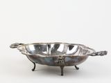 an antique silver plate with two handles and a bowl on a stand