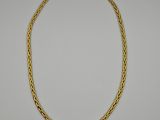 a gold necklace with a braid design on a white background
