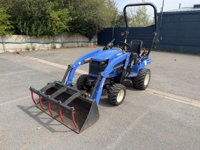 un petit tracteur bleu garé sur un parking