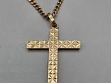 a gold cross pendant on a gold chain