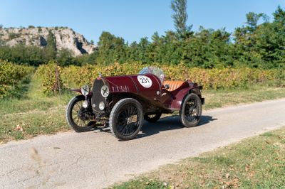 une voiture de collection qui roule sur la route, garée sur le bas-côté