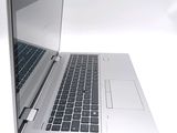 a silver laptop computer sitting on a white surface