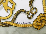 a close up of a tie with a chain and a key on it