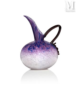 un vase en verre violet et blanc posé sur une surface blanche