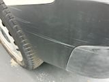a close up of a car ' s front bumper with a flat tire
