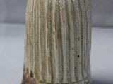 un petit vase sur lequel est représentée une femme en robe