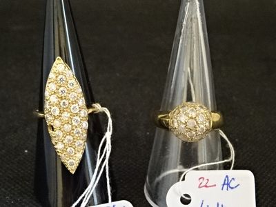 deux bagues en or et une bague en diamant posées sur un fond noir