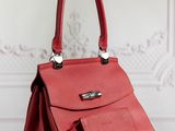 a red handbag sitting on top of a wooden table
