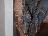 a statue of a man hanging from the side of a wall
