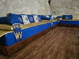 an image of a living room with blue couches and wood flooring