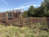 many cages with animals inside of them in a field