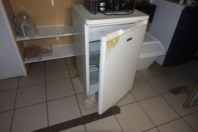 une photo d'un petit réfrigérateur dans un coin d'une cuisine
