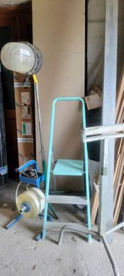 an image of a room with a ladder, chair and a fan