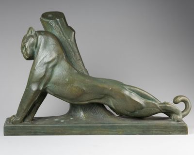 une statue en bronze représentant un lion couché sur le dos