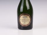 an old bottle of champagne sitting on a white surface