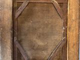 an old wooden picture frame hanging on a wall with a metal hook