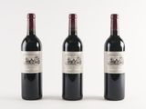 three bottles of wine are lined up on a white surface