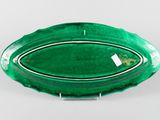 an oval green glass bowl with a silver rim on a white surface
