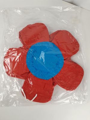 un gâteau en forme de fleur, rouge et bleu, dans un sac en plastique