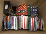 a cardboard box full of dvds and cds in it