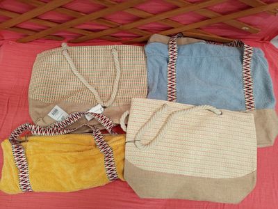three bags that are sitting on a pink blanket