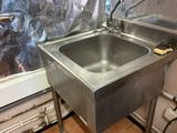 a stainless steel sink in the corner of a kitchen