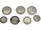 six silver buttons and a pin with a picture of a man ' s face