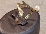 une bague sertie d'une perle, posée sur une boîte