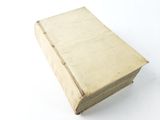 an old book sitting on top of a table on a white surface