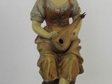 figurine of a woman sitting on a rock with a guitar
