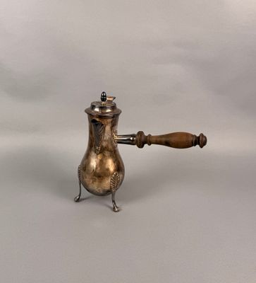 une cafetière ancienne en argent avec une poignée en bois sur fond blanc