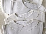 a pile of white sweaters on a white table