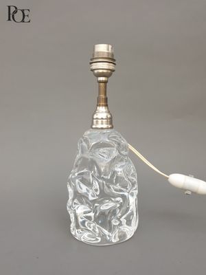 une bouteille en verre avec une poignée blanche posée sur une table