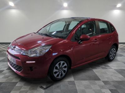la voiture rouge est garée dans le garage sur un sol en damier