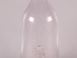 une bouteille en verre transparent munie d'un bouchon métallique