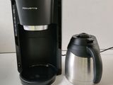 a coffee maker and a coffee pot sitting on a table