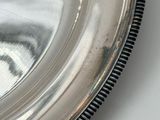 a silver plate with a black border around it