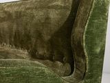 the back of a green velvet couch with buttons on it